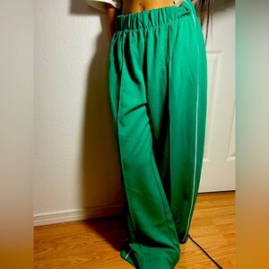 Green polyester wide leg pants with white thin stripes on the side.